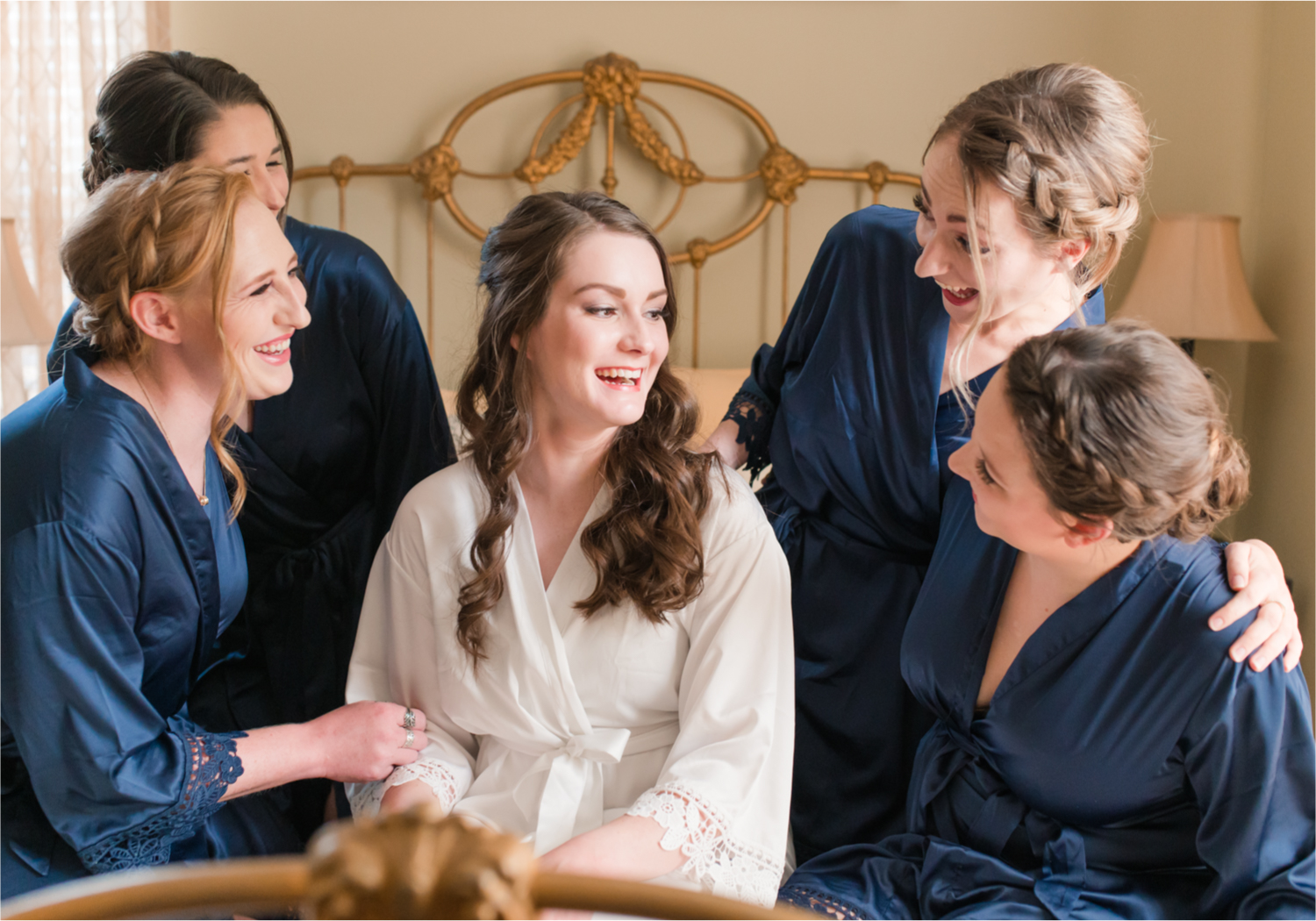 Summer Ellis Ranch Wedding in Loveland Colorado | Britni Girard Photography | Wedding Photo and Video Team | Bride hair Dondi AtWow from Sola Salon in Loveland | Getting Ready at Air BnB | Bride and bridesmaids in dark blue robes on bed