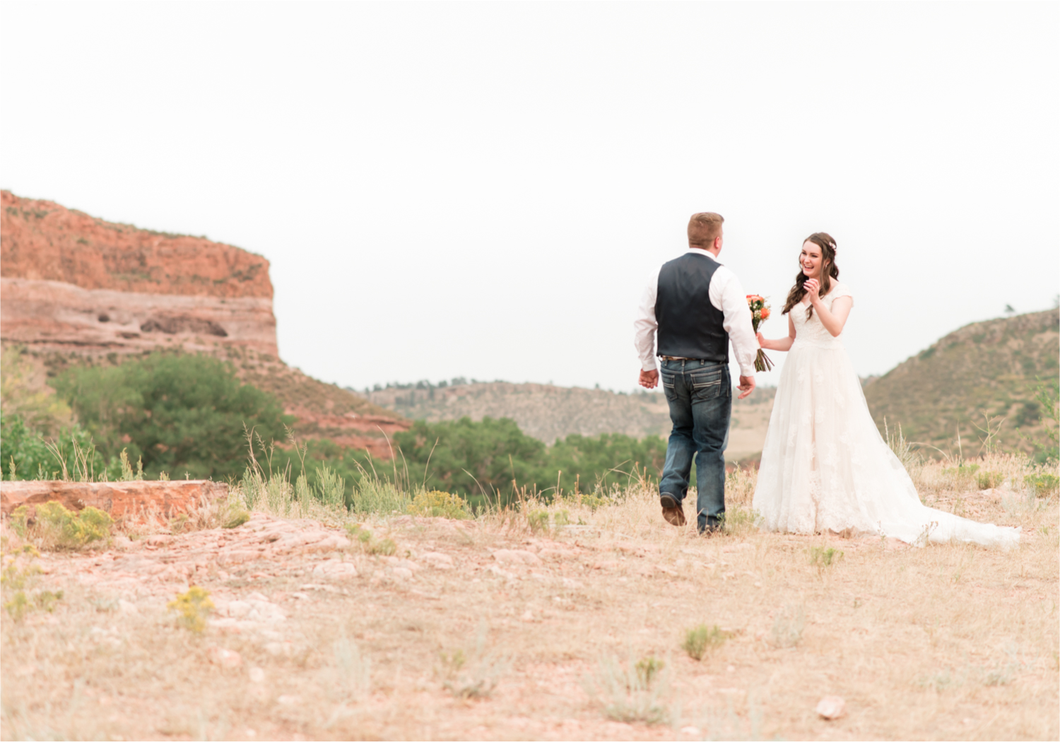 Summer Ellis Ranch Wedding in Loveland Colorado | Britni Girard Photography | Wedding Photo and Video Team | Dark Blue and Orange Bridal Bouquet | First Look on top of colorado mountain | Red Rocks