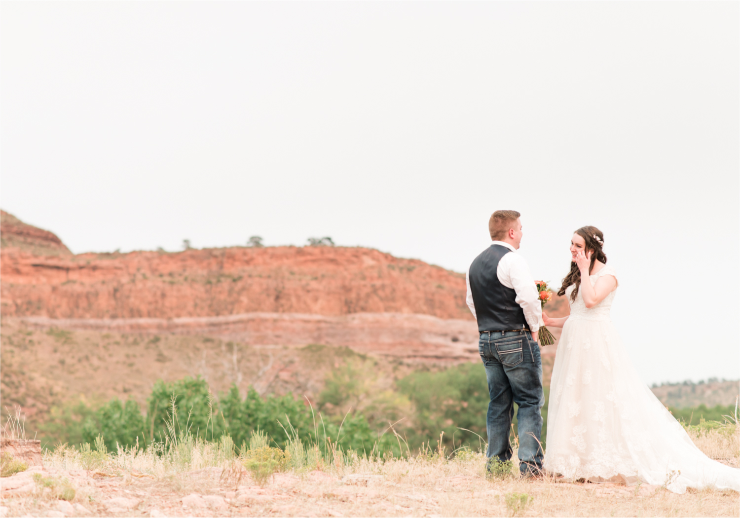 Summer Ellis Ranch Wedding in Loveland Colorado | Britni Girard Photography | Wedding Photo and Video Team | Dark Blue and Orange Bridal Bouquet | First Look on top of colorado mountain | Red Rocks